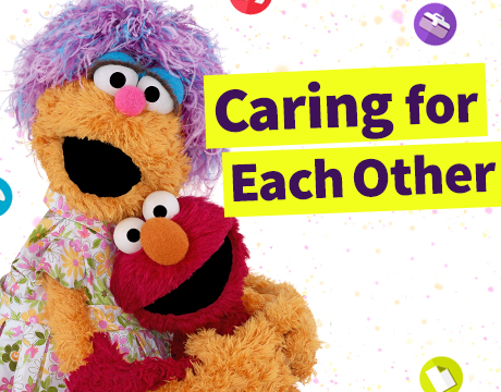 Sesame Workshop: Caring for Each Other. Muppets Mae and Elmo smiling and hugging. Mae has purple hair and is wearing a flower printed dress. Elmo has red fur.